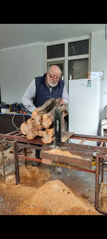Black hyundai chainsaw cutting through a log.