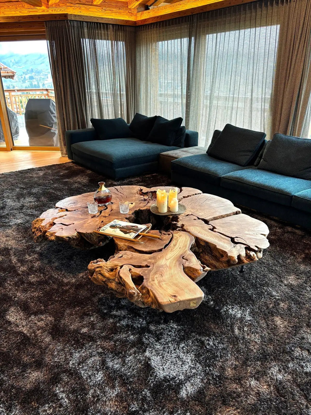 A rustic, natural wood live-edge coffee table with a raw, organic shape and visible grain.